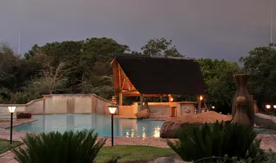 a swimming pool with a gazebo next to a house at Mabula Game Lodge in Mabula