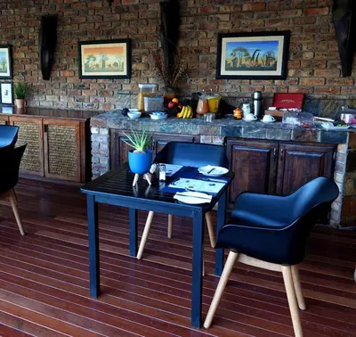 a table and chairs in front of a bar at Crocodile Kruger Safari Lodge in Marloth Park