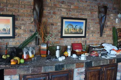 a brick wall with a counter with food on it at Crocodile Kruger Safari Lodge in Marloth Park