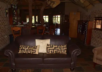 a leather couch with pillows in a living room at Crocodile Kruger Safari Lodge in Marloth Park