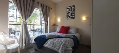 a bedroom with a bed with red pillows and a window at 13 @ Rhinoroad Nelspruit in Nelspruit