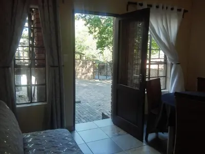 an open door to a patio with a view of a yard at 13 @ Rhinoroad Nelspruit in Nelspruit