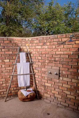a towel ladder leaning against a brick wall at La Kruger Lifestyle Lodge - No Loadshedding in Marloth Park