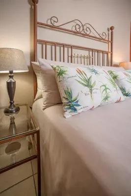 a bed with a pillow and a lamp on a table at La Kruger Lifestyle Lodge - No Loadshedding in Marloth Park