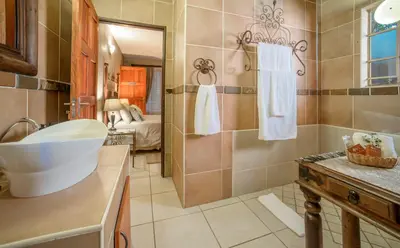 a bathroom with a tub and a sink and a shower at La Kruger Lifestyle Lodge - No Loadshedding in Marloth Park