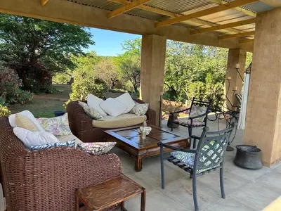 a patio with two couches and a table and chairs at KwaThabisile Bush Retreat in Cullinan
