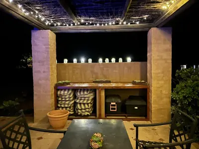 a patio with a table and a bar with lights at KwaThabisile Bush Retreat in Cullinan