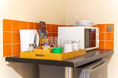 a kitchen counter with a counter top with a microwave at Pumleni Guesthouse in Hartbeespoort
