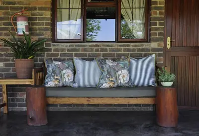 a bench with pillows on a brick wall at Grincourt B&B- with No Load shedding in Polokwane