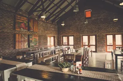 a restaurant with tables and chairs and a brick wall at Grincourt B&B- with No Load shedding in Polokwane