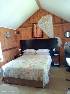a bedroom with a bed in a room with wooden walls at Pumba's Lookout in Barberton