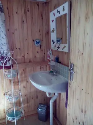 a bathroom with a sink in a wooden wall at Pumba's Lookout in Barberton