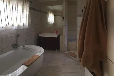 a bathroom with a tub and a sink at Mountain Creek Lodge in Hazyview