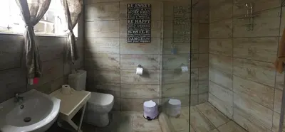 a bathroom with a toilet and a sink and a shower at Mountain Creek Lodge in Hazyview