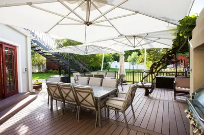 a patio with a table and chairs under a white umbrella at The Browns' Luxury Suites & Cottage in Dullstroom