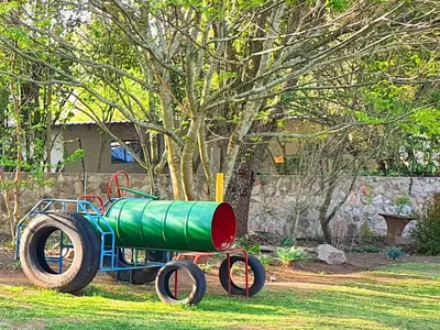 a green cannon sitting on the grass in a yard at The Browns' Luxury Suites & Cottage in Dullstroom