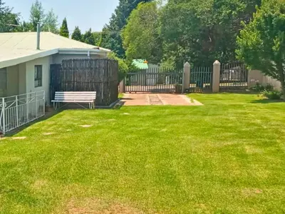 a yard with a bench and a fence at The Browns' Luxury Suites & Cottage in Dullstroom