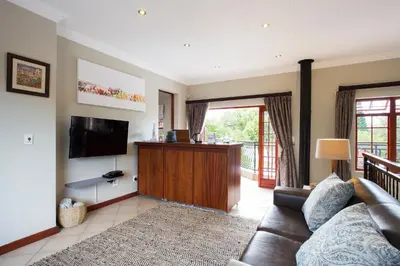 a living room with a couch and a flat screen tv at The Browns' Luxury Suites & Cottage in Dullstroom