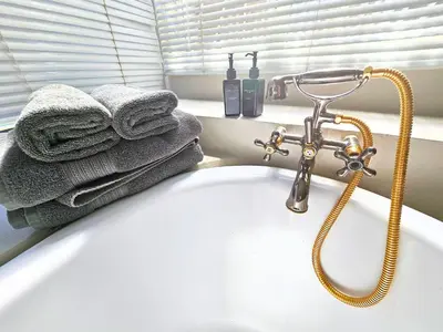 a bathroom sink with towels and a faucet at The Browns' Luxury Suites & Cottage in Dullstroom