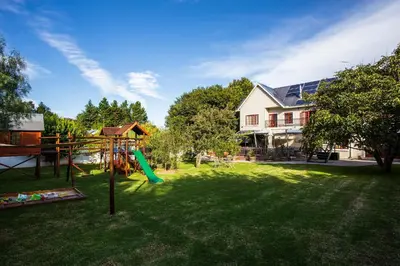 a yard with a playground in front of a house at The Browns' Luxury Suites & Cottage in Dullstroom