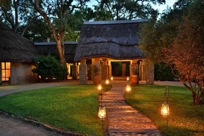 a pathway leading to a house with lights on it at Imbali Safari Lodge in Mluwati Concession