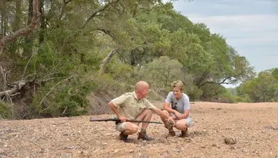 a man and a young girl playing with a toy at Imbali Safari Lodge in Mluwati Concession