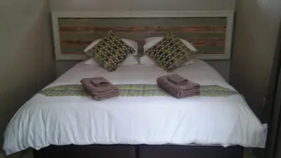 a large bed with towels on top of it at hanna's place in Polokwane