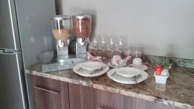a kitchen counter with plates and glasses and a refrigerator at hanna's place in Polokwane