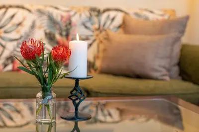 a candle and a vase with flowers on a table at Oliver`s in White River