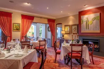 a restaurant with tables and chairs and a fireplace at Oliver`s in White River