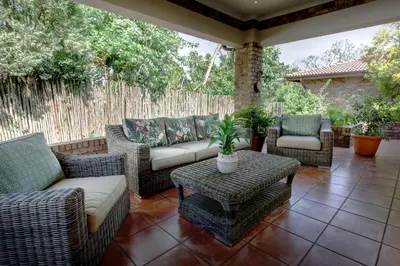 a patio with wicker chairs and a couch and a table at Oliver`s in White River