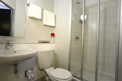 a bathroom with a toilet and a sink and a shower at Inani Hotel Morning Star in Pretoria