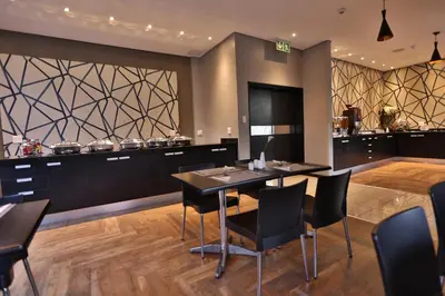 a dining room with a table and chairs at Inani Hotel Morning Star in Pretoria