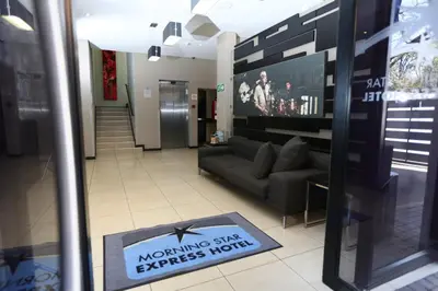 a living room with a couch and a sign on the window at Inani Hotel Morning Star in Pretoria