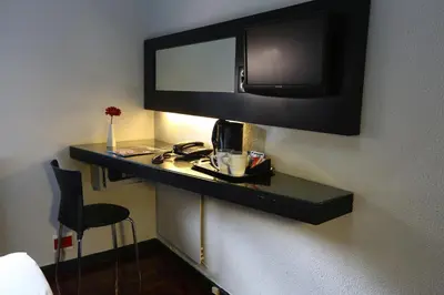 a black shelf with a mirror on a wall at Inani Hotel Morning Star in Pretoria