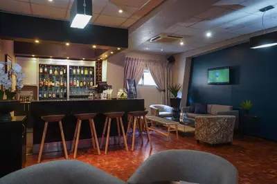 a bar in a room with chairs and a couch at Inani Hotel Morning Star in Pretoria