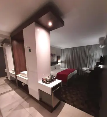 a hotel room with a bed and a mirror at Palm Swift Luxury Accommodation in Brits