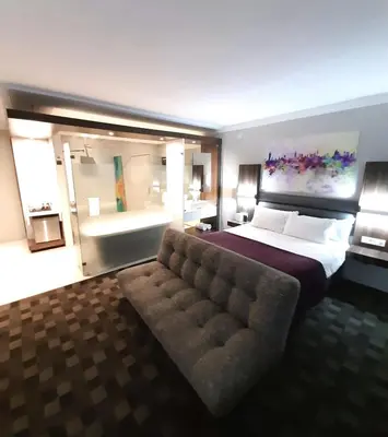 a large bedroom with a bed and a couch at Palm Swift Luxury Accommodation in Brits