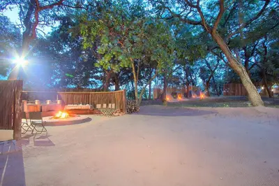 a park with a bench and a table and trees at Kruger Adventure Lodge in Hazyview