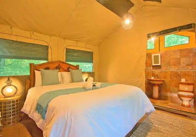 a bedroom with a bed in a tent at Kruger Adventure Lodge in Hazyview