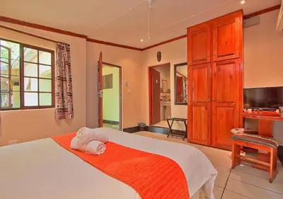 a bedroom with a bed and a flat screen tv at Kruger Adventure Lodge in Hazyview