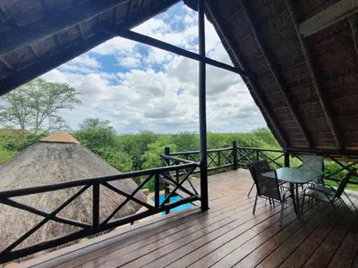 a view of a deck with a table and a haystack at Giraffe plains in Marloth Park