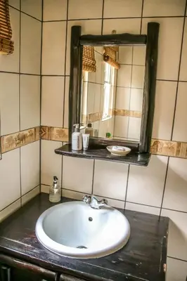 a bathroom with a sink and a mirror at Giraffe plains in Marloth Park