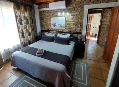 a bedroom with a bed with a book on it at Giraffe plains in Marloth Park