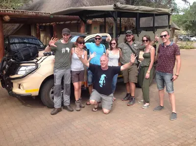 a group of people posing for a picture in front of a car at Old Vic Travellers Inn Nelspruit in Nelspruit