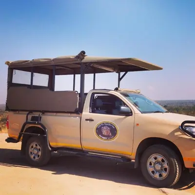 a white truck with a surfboard on top of it at Old Vic Travellers Inn Nelspruit in Nelspruit