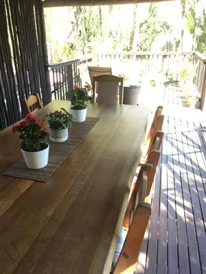a wooden table with potted plants on a deck at Old Vic Travellers Inn Nelspruit in Nelspruit