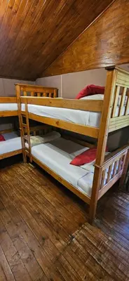 two bunk beds in a room with a wooden ceiling at Old Vic Travellers Inn Nelspruit in Nelspruit