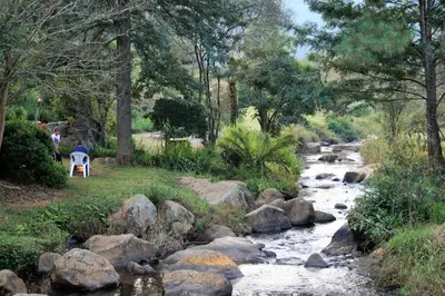a stream with rocks and a person standing next to a river at Sabie Star in Sabie