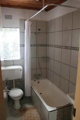 a bathroom with a tub and a toilet and a sink at Sabie Star in Sabie